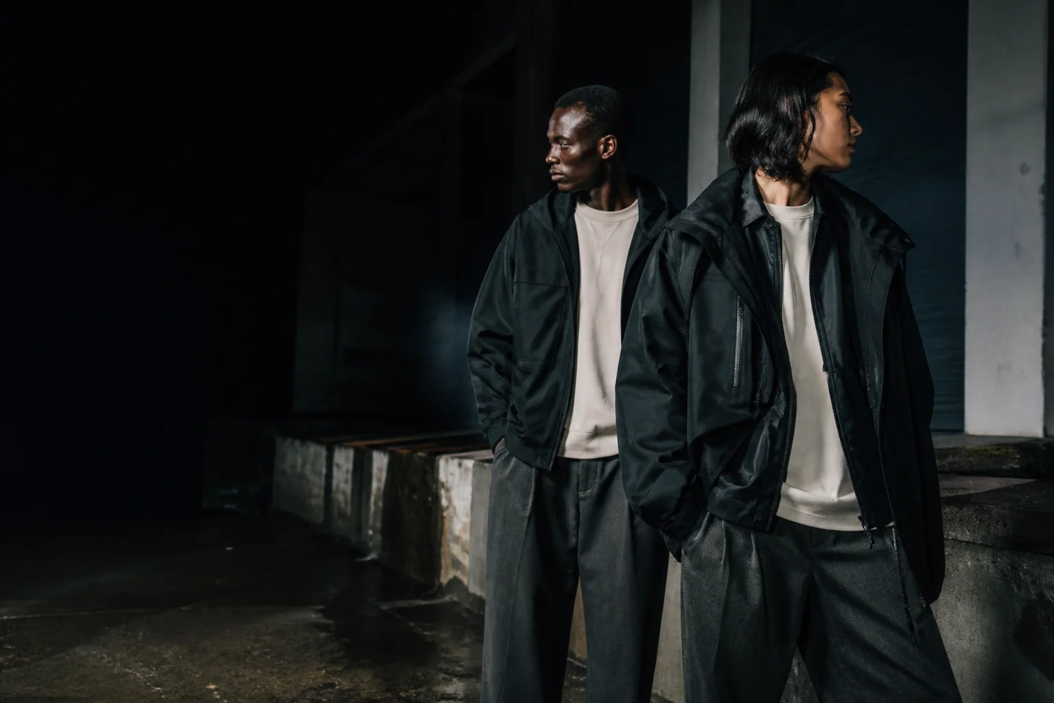 Two models wearing dark HEIST outerwear